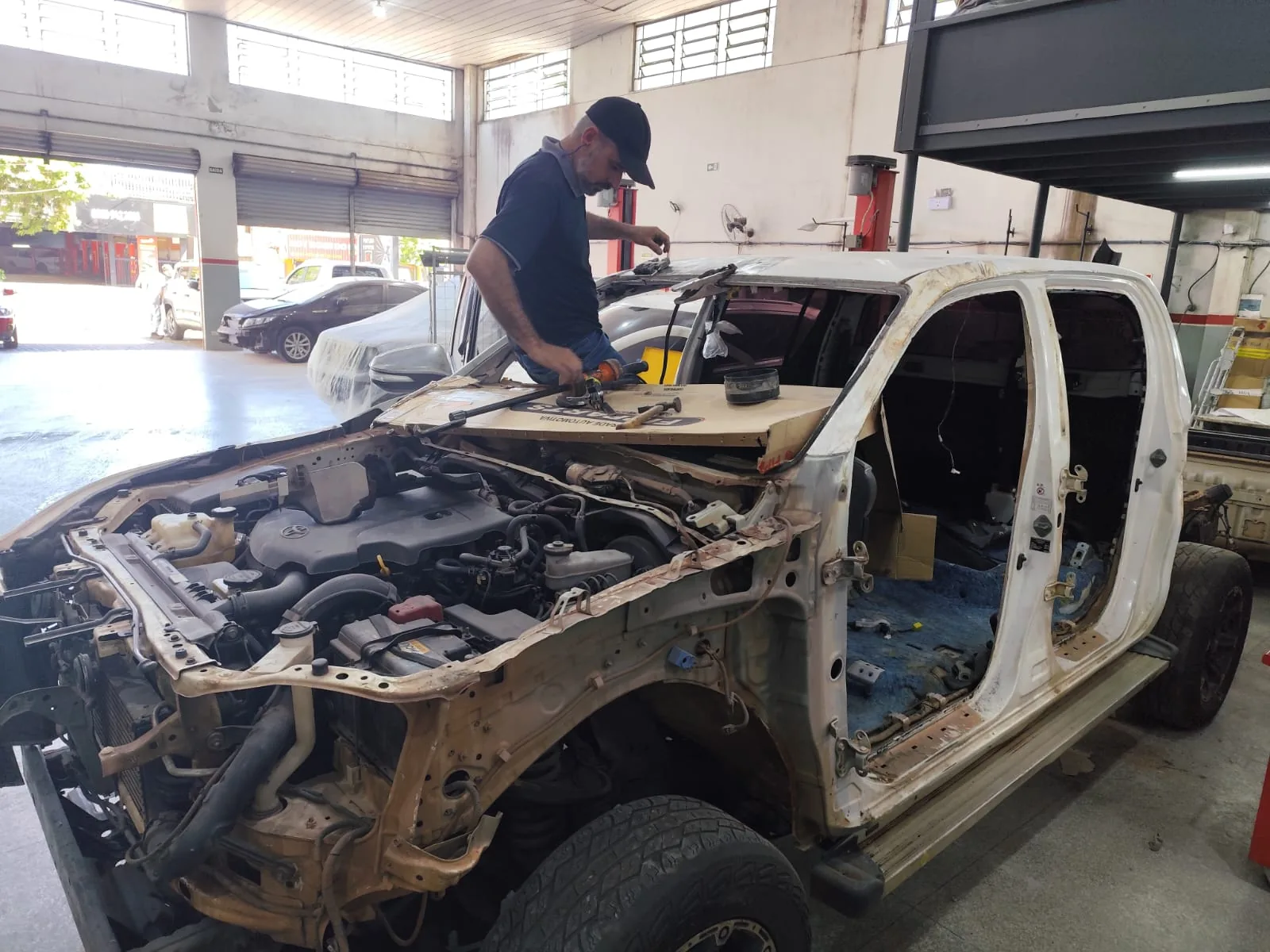 Hilux desmontada durante a funilaria